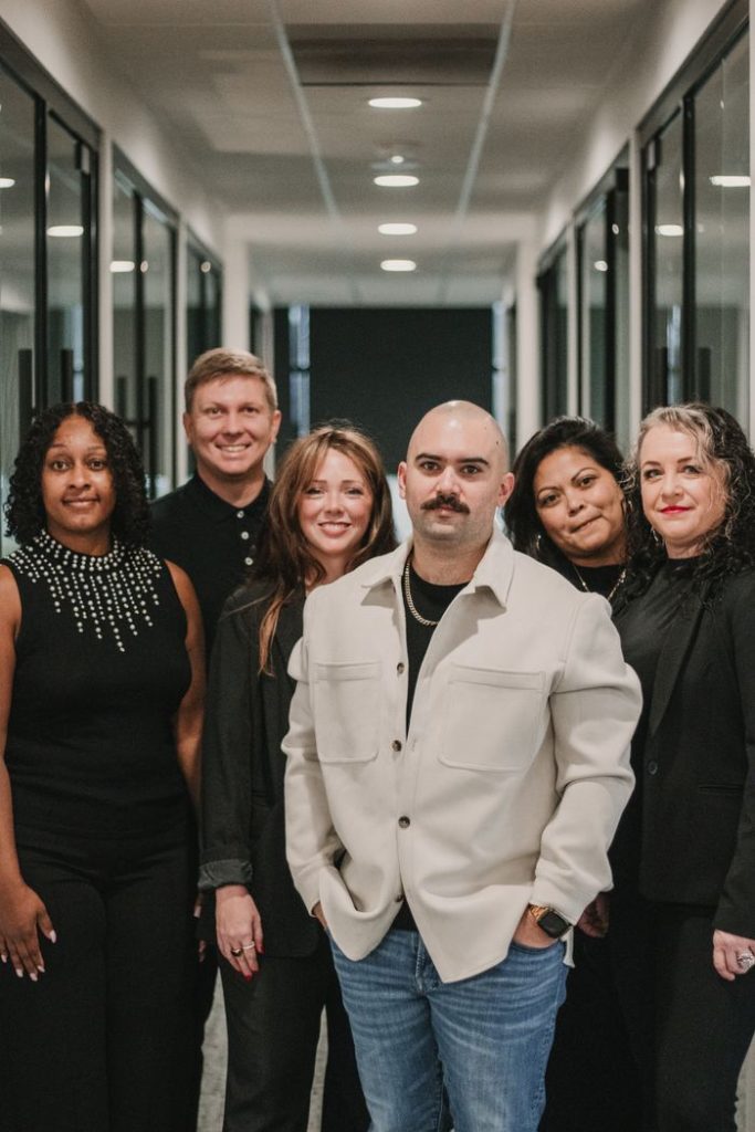 A diverse team of real estate agents posing confidently in an office.