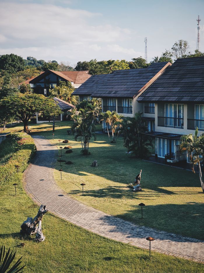 A picturesque view of resort villas amid lush, green gardens in Sulawesi Utara, Indonesia.
